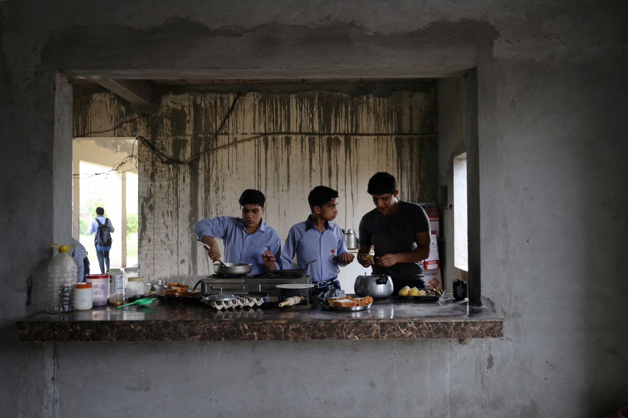 13 år gamle Anjali, 15 år gamle Naitik Rana og 16 år gamle Swati Berwal lager seg frokost av kokte egg - Foto: Anushree Fadnavis / Reuters