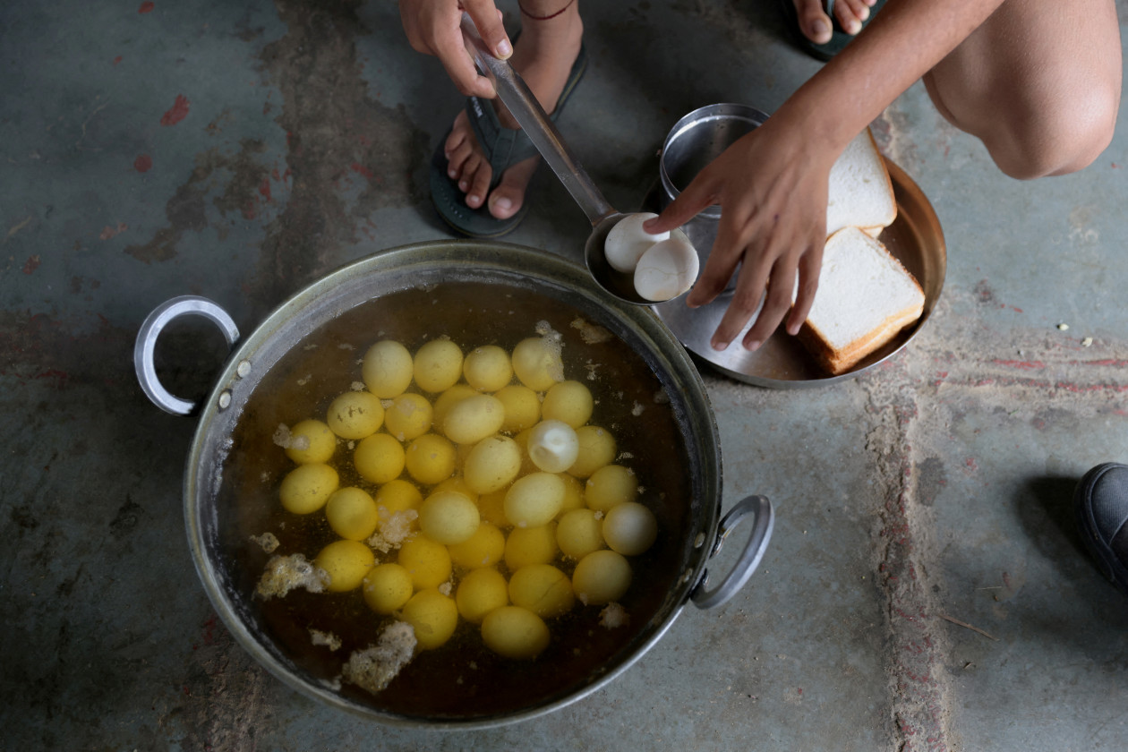 13 år gamle Anjali, 15 år gamle Naitik Rana og 16 år gamle Swati Berwal lager seg frokost av kokte egg - Foto: Anushree Fadnavis / Reuters