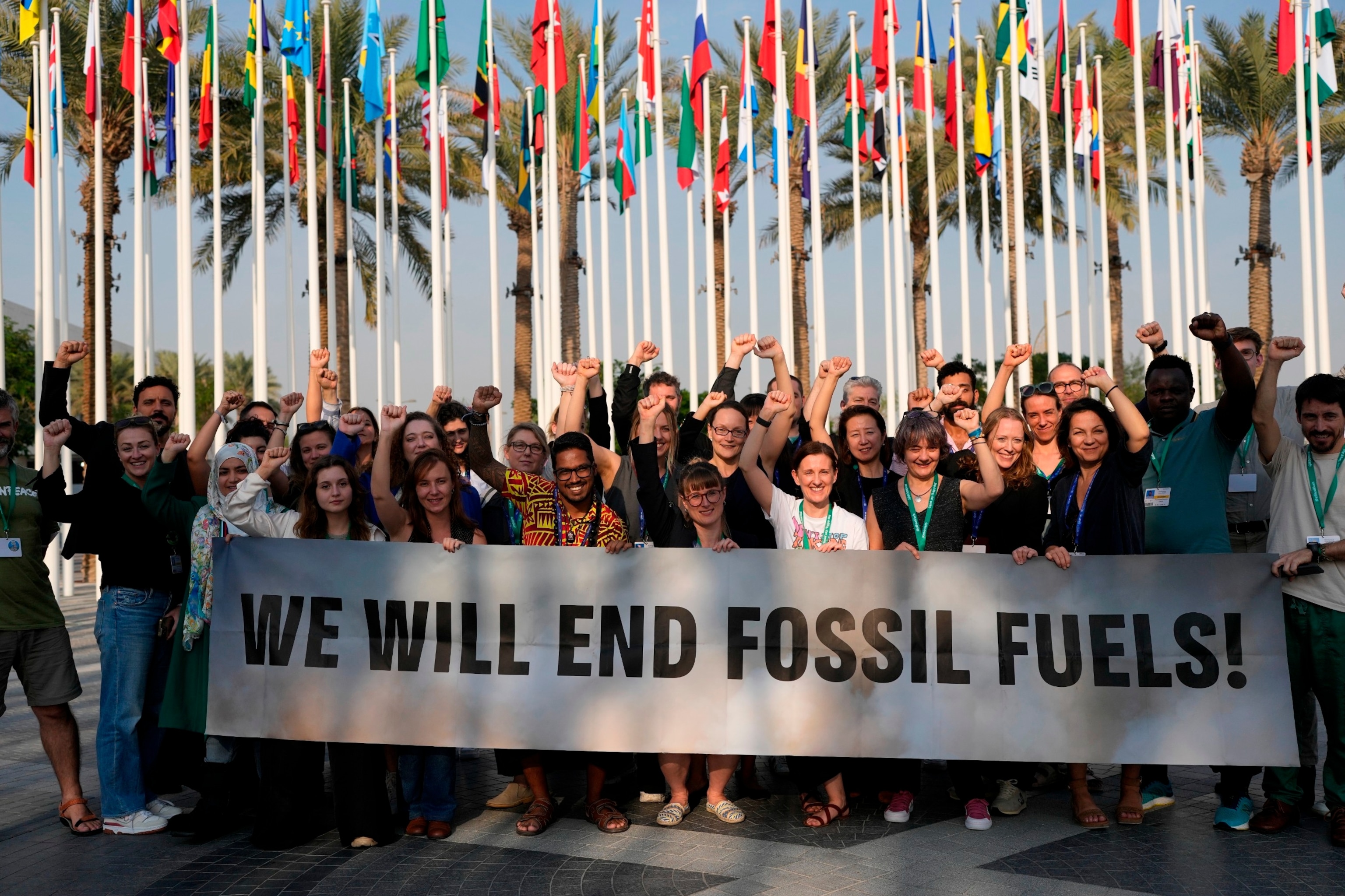 FOTO: Medlemmer av Greenpeace samles for et bilde rundt et skilt der det står «vi vil gjøre slutt på fossilt brensel» på COP28 FNs klimatoppmøte, 13. desember 2023, i Dubai, De forente arabiske emirater.